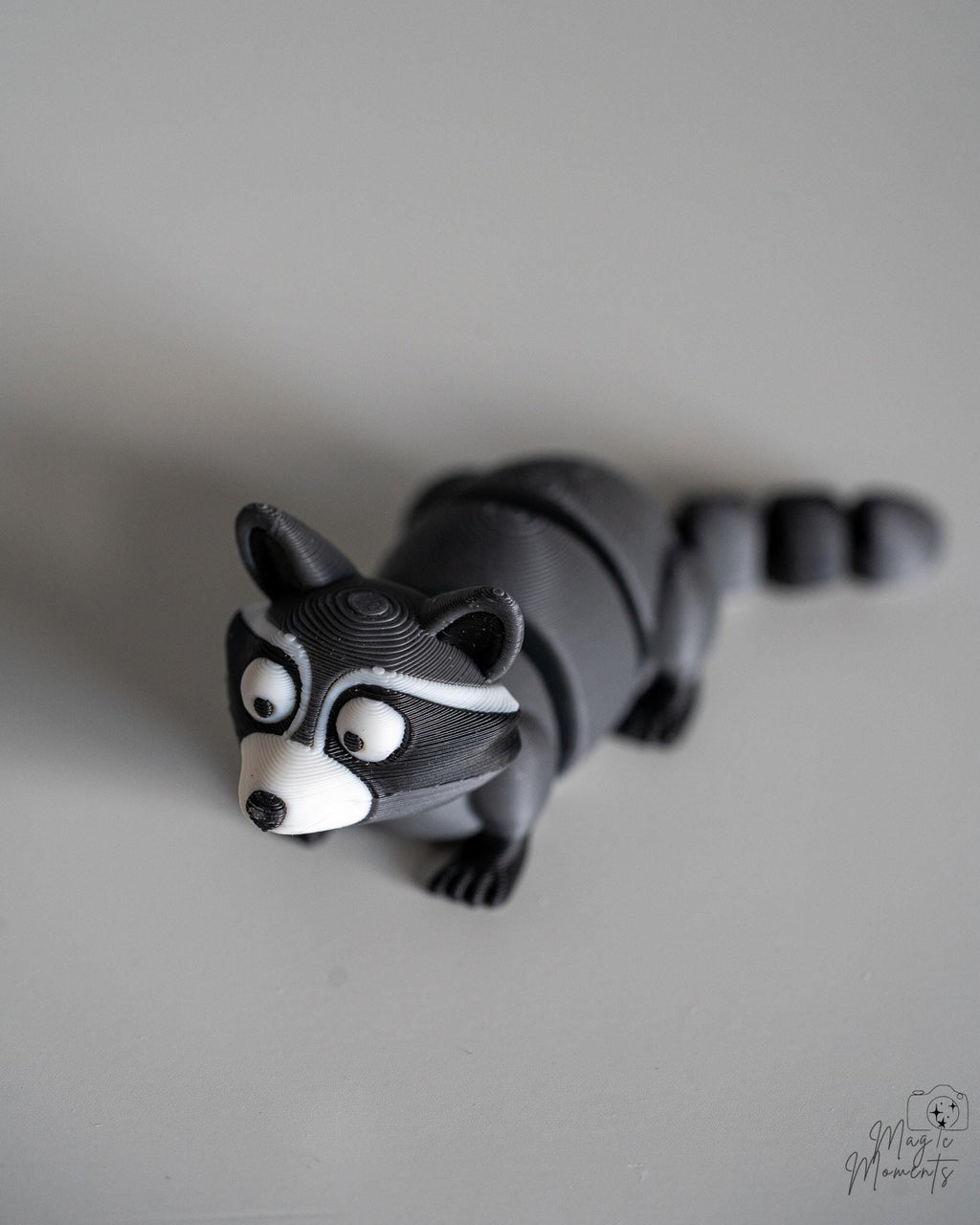 Articulated raccoon figure with segmented body and striped tail