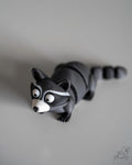 Articulated raccoon figure with segmented body and striped tail