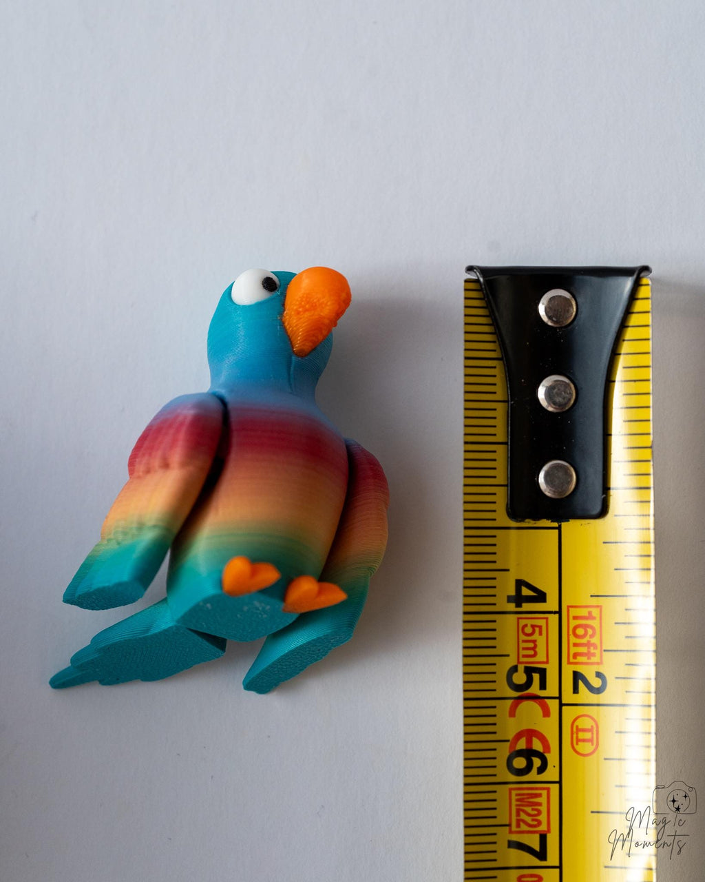 bird figurine next to measuring tape for scale