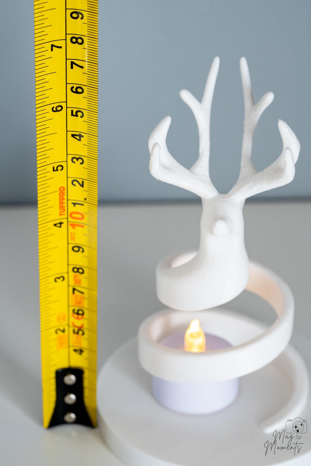 White deer tealight holder next to measuring tape for scale