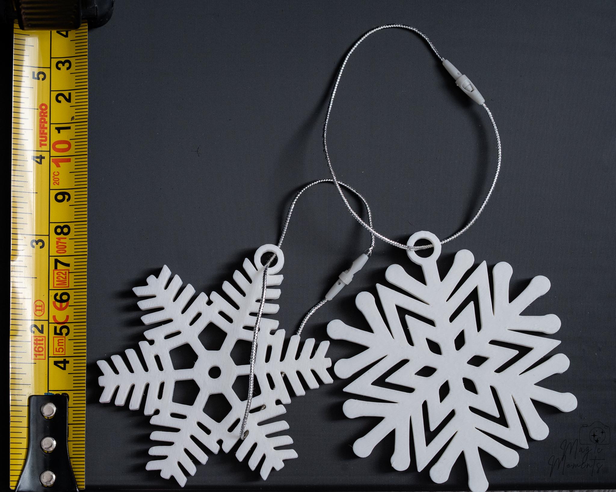 white snowflake christmas ornaments next to measuring tape for scale