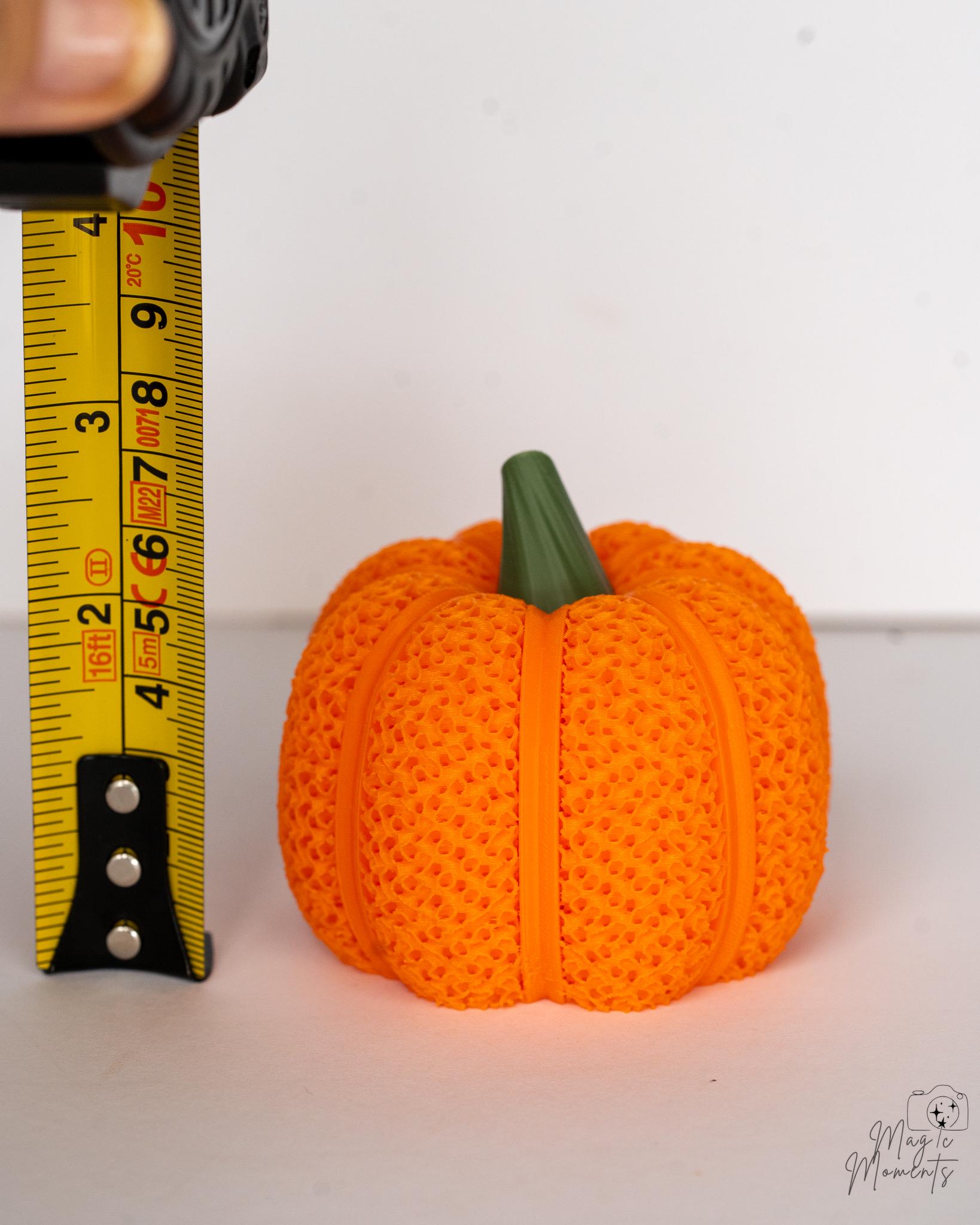 Mesh pumpkin candle holder for Halloween decor next to measuring tape for scale