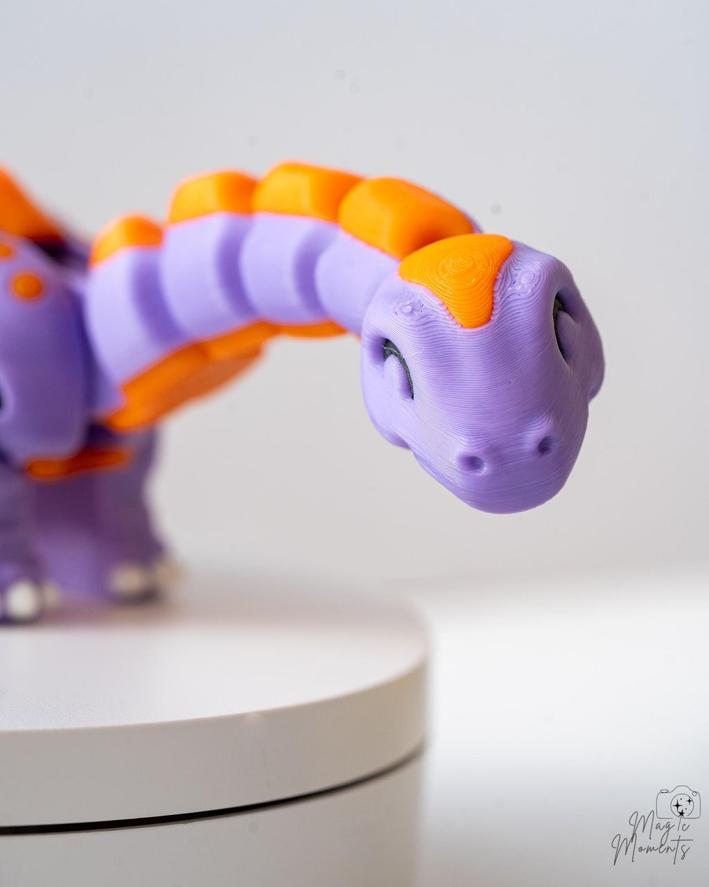 Cute smiling dinosaur figure with orange spikes and tail details