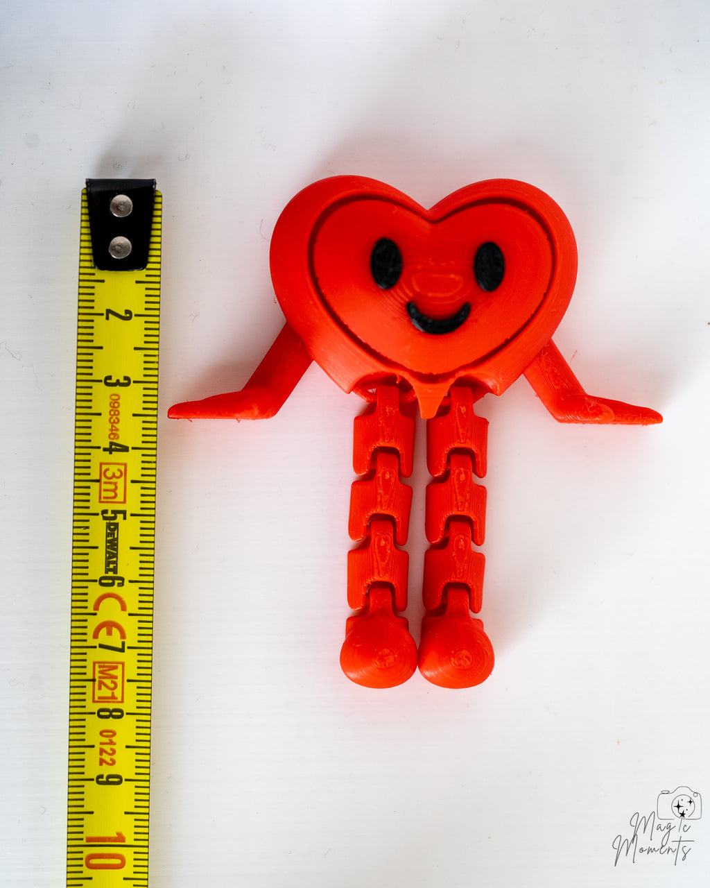 Heart clicker next to measuring tape for scale