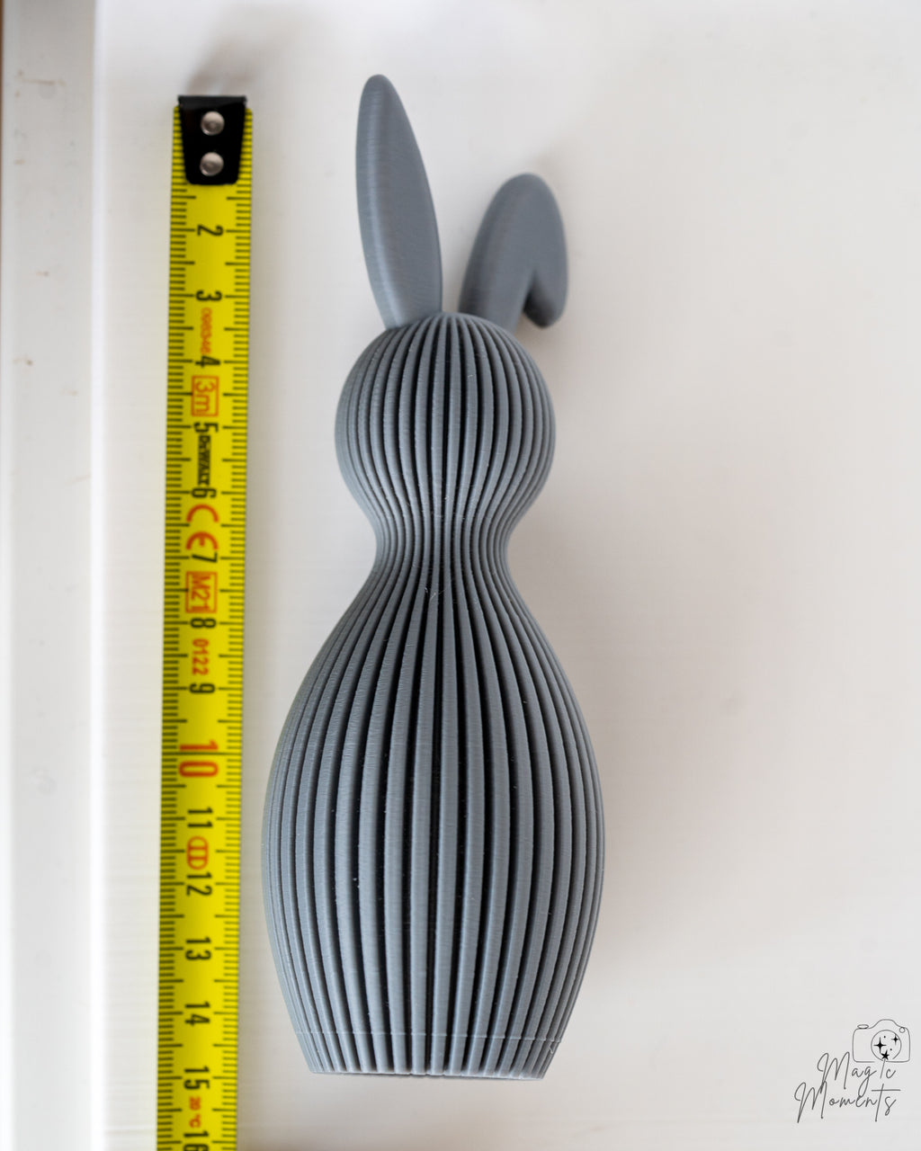 Grey bunny figure next to measuring tape for scale