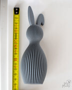 Grey bunny figure next to measuring tape for scale