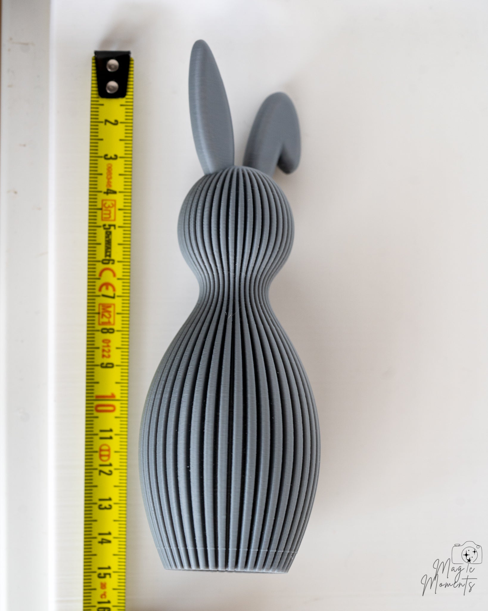Grey bunny figure next to measuring tape for scale