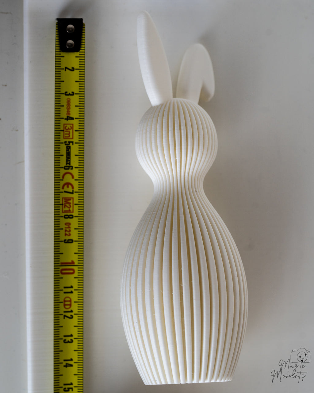 White bunny figure next to measuring tape for scale