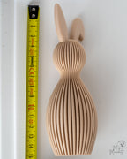 Beige bunny figure next to measuring tape for scale