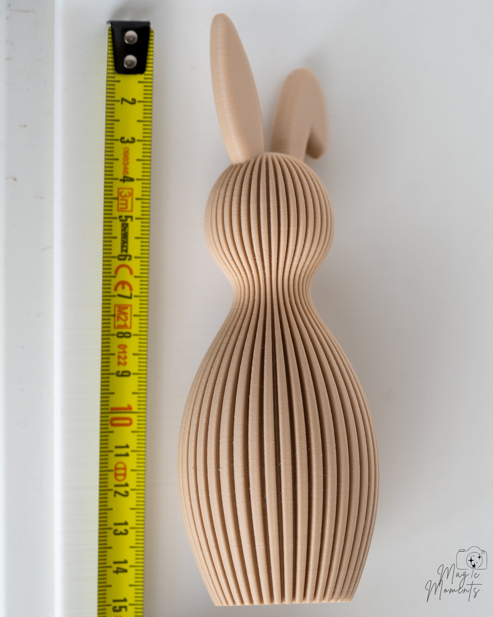 Beige bunny figure next to measuring tape for scale