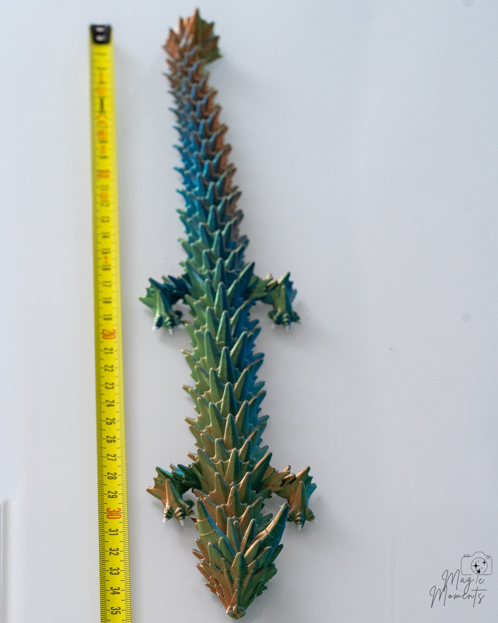 Crystal dragon figure next to measuring tape for scale