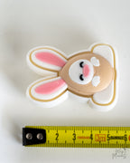 Pink bunny clicker next to measuring tape for scale