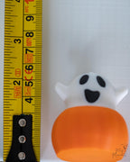 Ghost pumpkin figure with surprised face next to measuring tape for scale