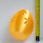 Gold egg tealight holder next to measuring tape for scale