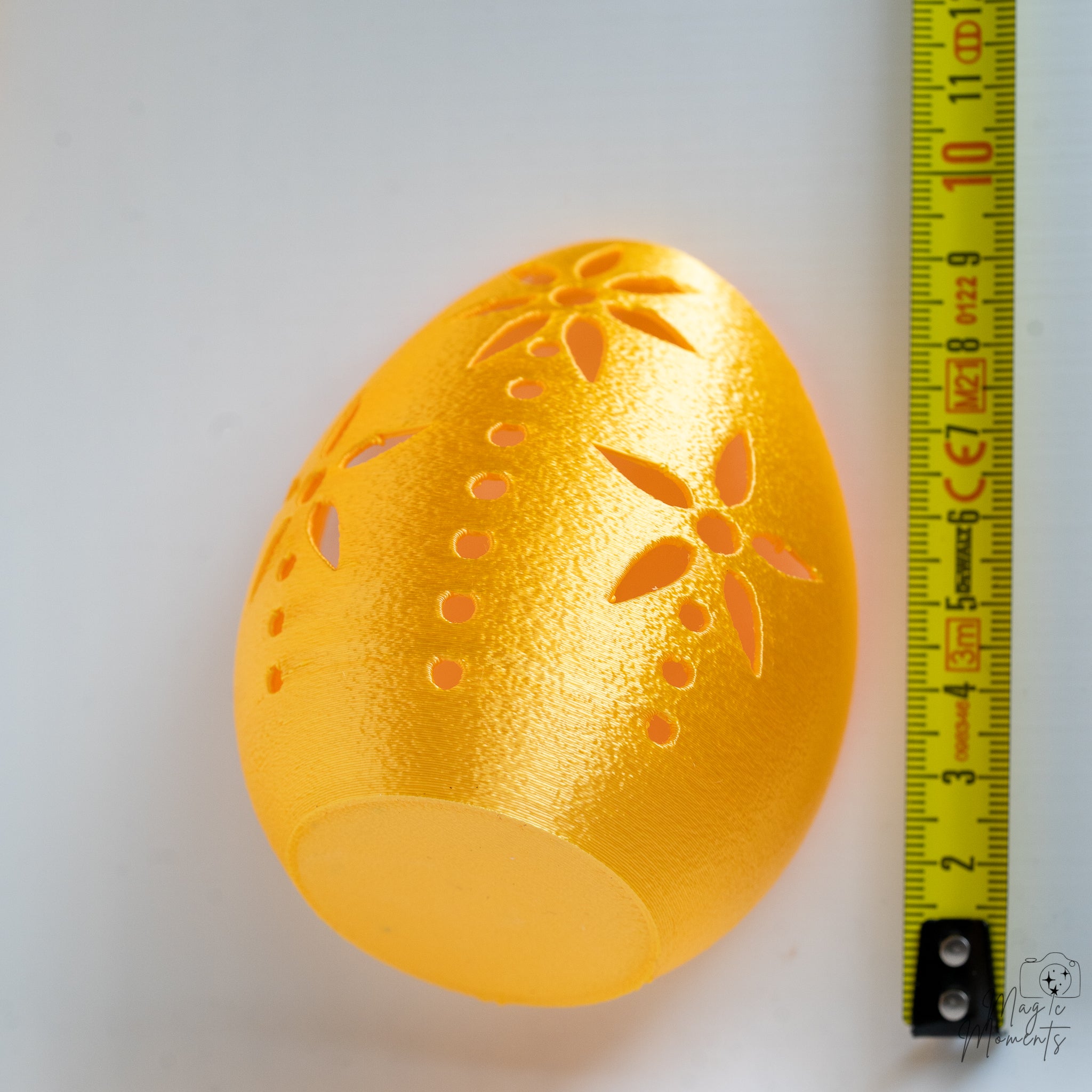 Gold egg tealight holder next to measuring tape for scale