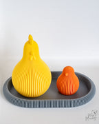Yellow and orange ribbed chicken figures on grey tray