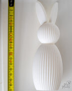 White bunny figure next to measuring tape for scale