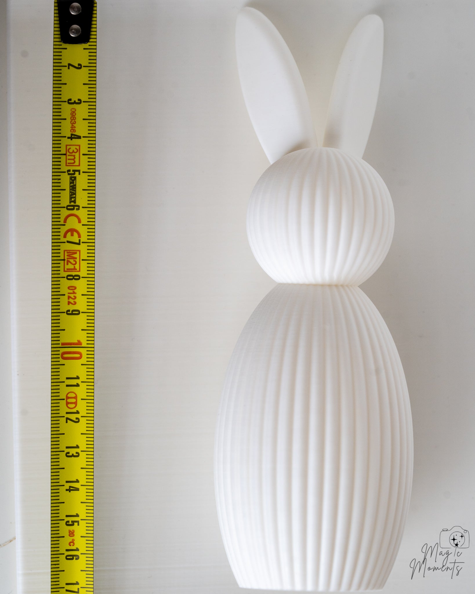 White bunny figure next to measuring tape for scale