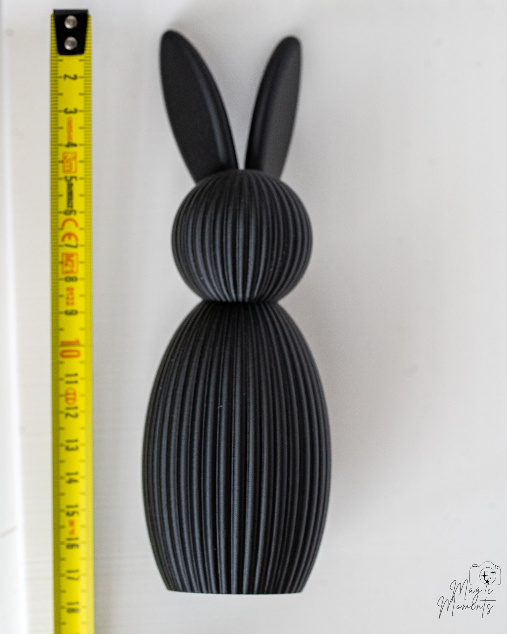 Black bunny figure next to measuring tape for scale