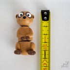 meerkat figurine next to measuring tape for scale