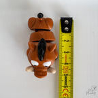 warthog figurine next to measuring tape for scale