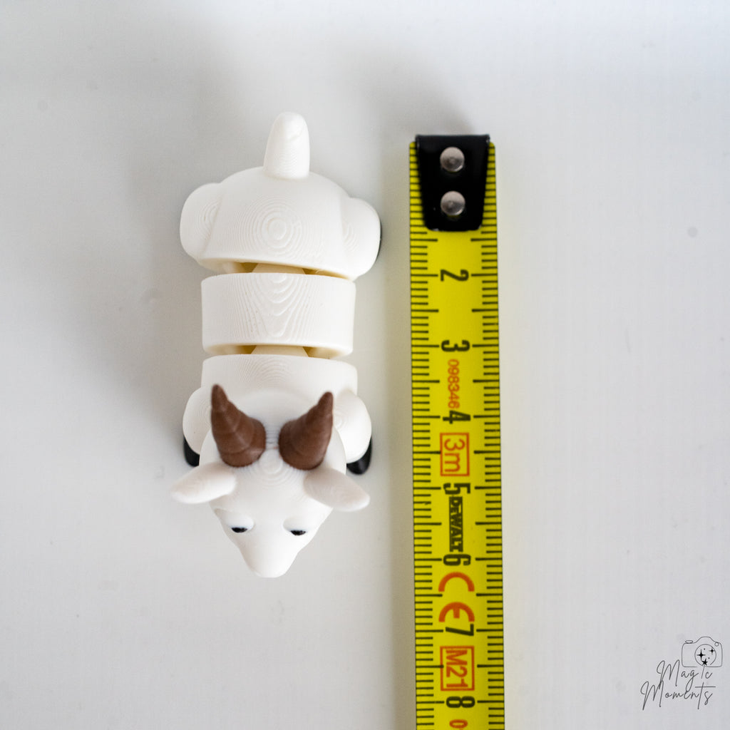 goat figurine next to measuring tape for scale