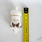 goat figurine next to measuring tape for scale