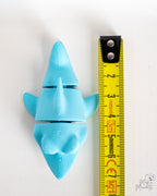 Light blue shark figure next to measuring tape for scale