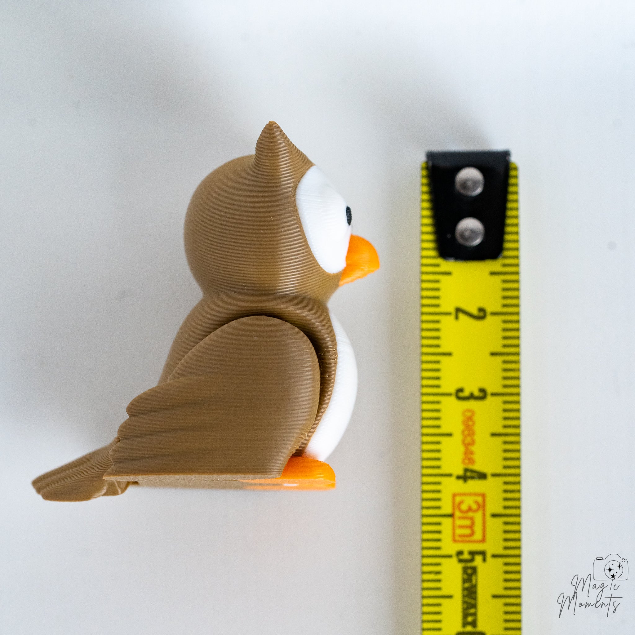 owl figurine next to measuring tape for scale