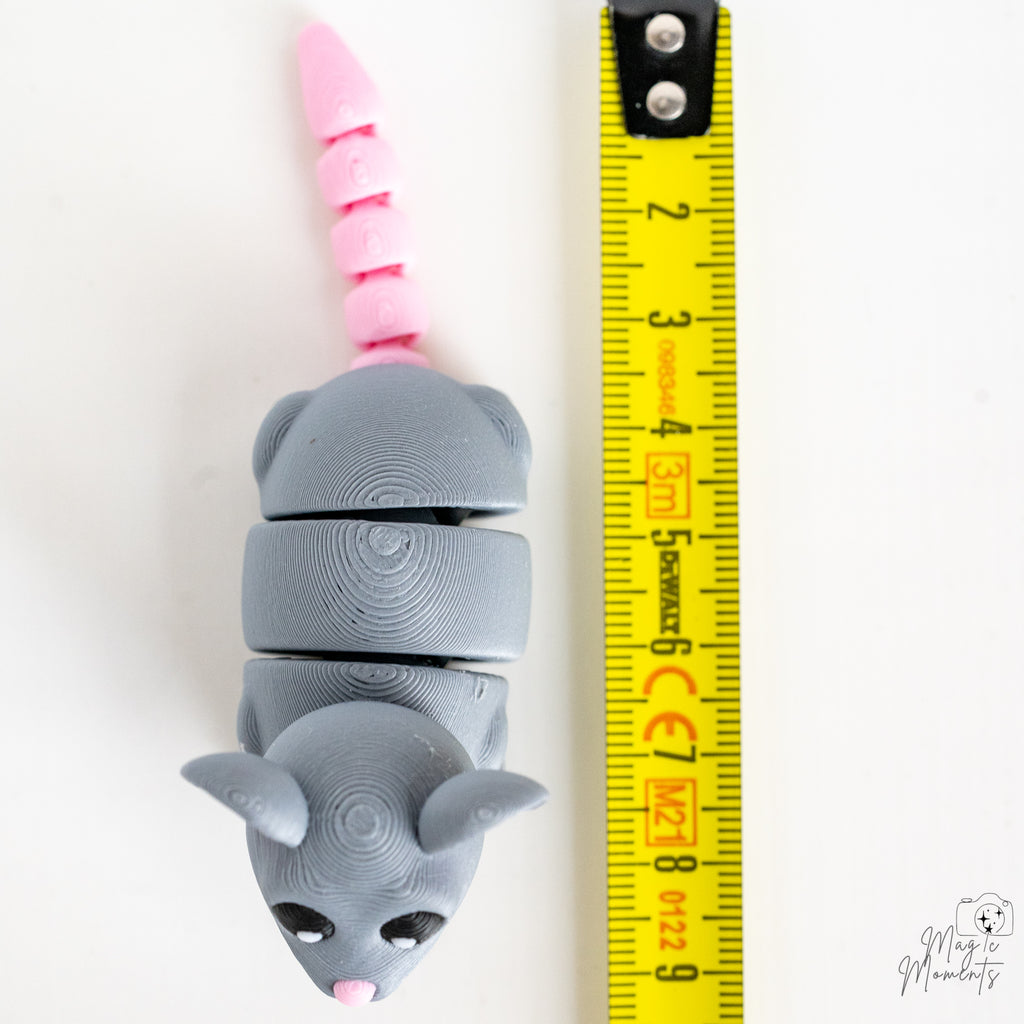 Grey rat figure next to measuring tape for scale