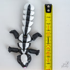 skunk figurine next to measuring tape for scale