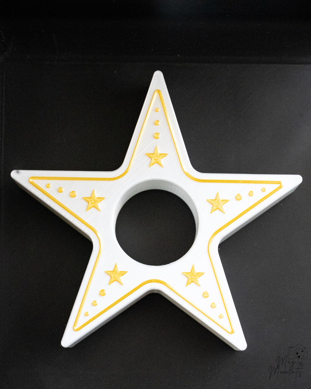 Star-shaped candle holder with gold accents on a black background
