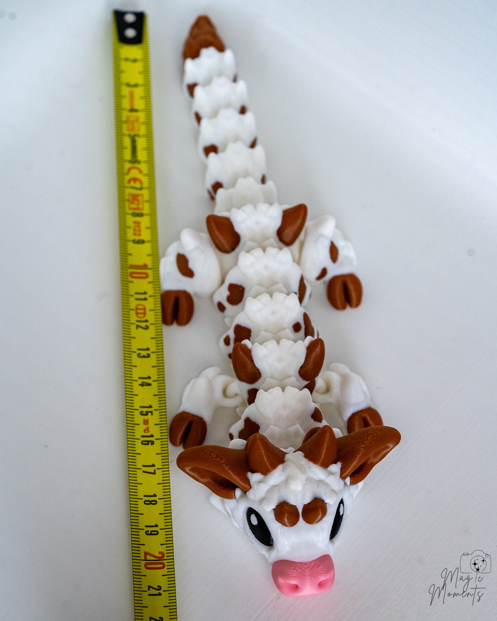 cow dragon next to a measuring tape for scale 