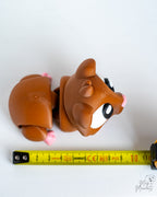Guinea pig figure next to measuring tape for scale