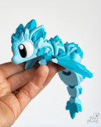 Flexible articulated crystal dragon held in hand