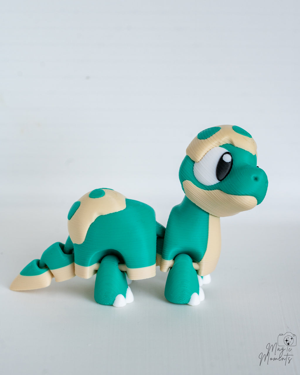 Teal baby dinosaur figure with spotted shell pattern