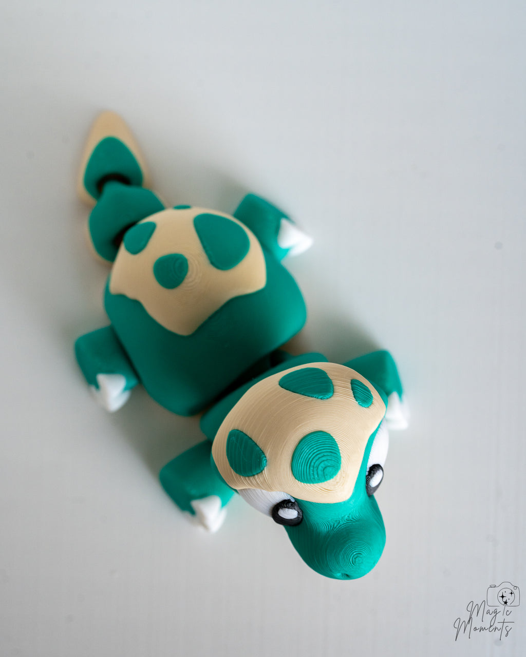 Teal baby dinosaur viewed from above