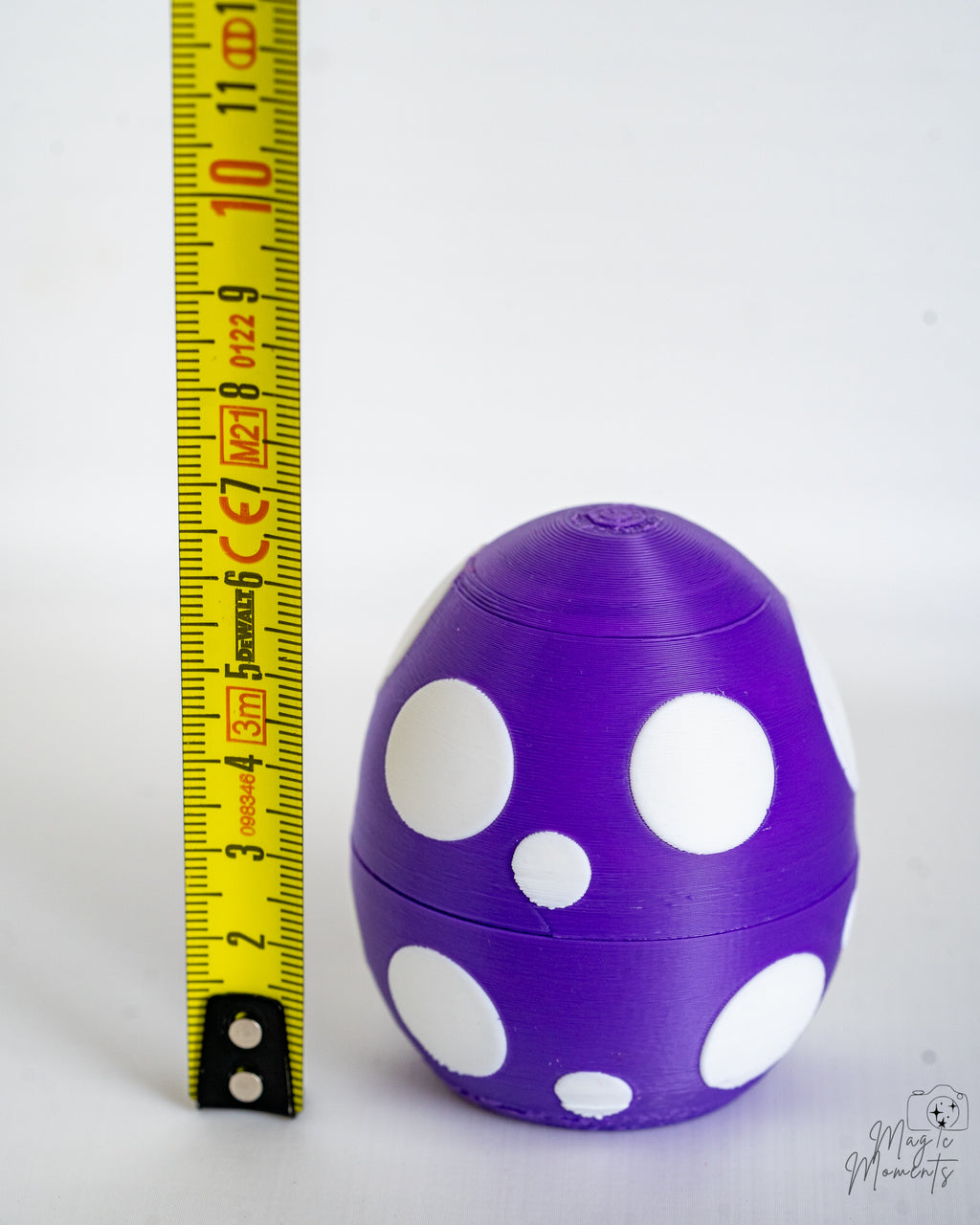 Purple dragon egg next to measuring tape for scale