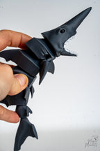 Hand holding articulated shark showing flexible segmented movement