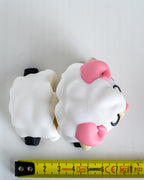 Cute sheep figure next to measuring tape for scale