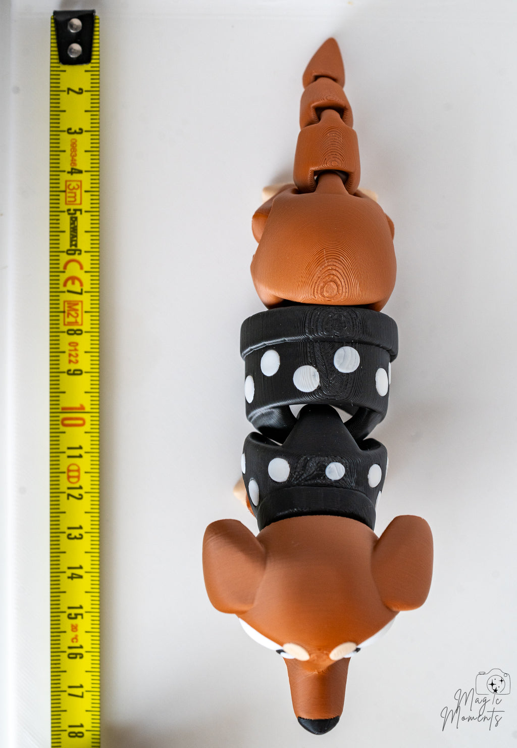 Dachshund figure next to measuring tape for scale