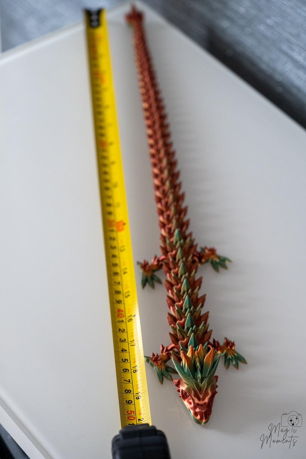 Crystal dragon next to measuring tape for scale