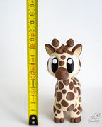 Giraffe figure next to measuring tape for scale