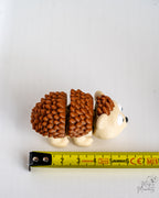 Hedgehog figure next to measuring tape for scale