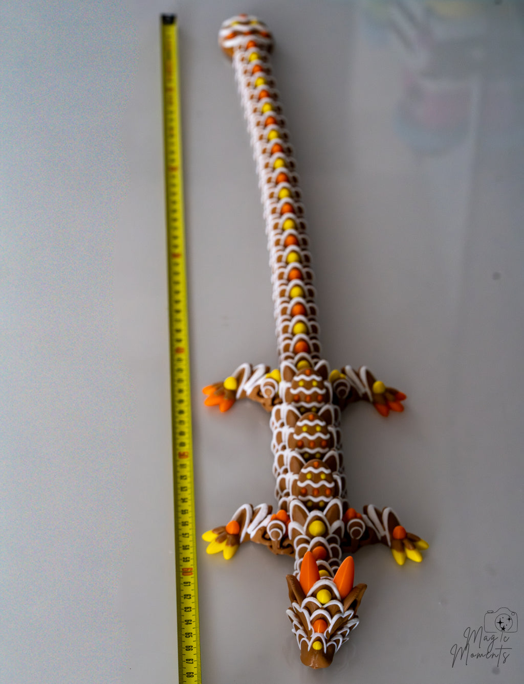 Gingerbread dragon figure next to measuring tape for scale