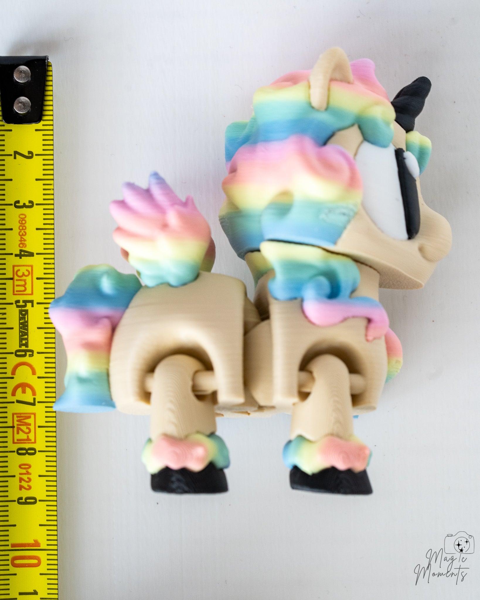 Pastel unicorn figure next to measuring tape for scale