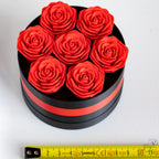 Rose gift box next to measuring tape for scale