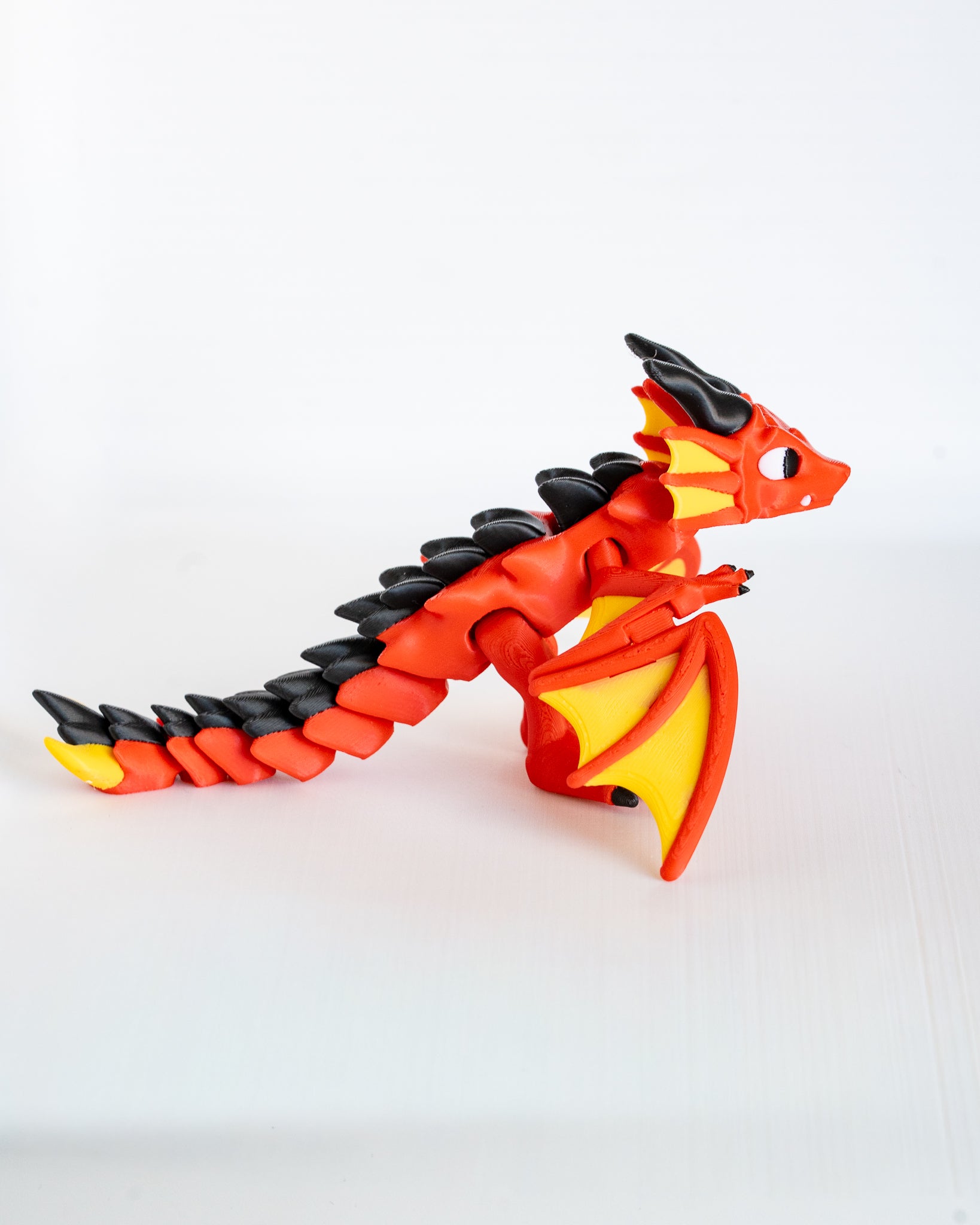 Articulated red dragon figurine with yellow wings