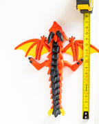 Winged dragon figure next to measuring tape for scale