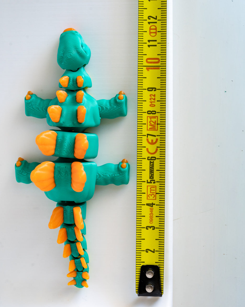 Stegosaurus figure next to measuring tape for scale